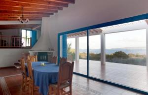 una sala da pranzo con tavolo blu e balcone di CASA CAN PARRA a Sant Francesc Xavier
