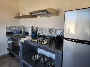 a kitchen with a stove and a refrigerator at Bungalow Vista Sierra Laguna in San Carlos