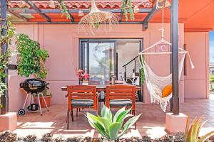 un patio con hamaca, mesa y sillas en Villa Fénix - Oasis in Natural Reserve, en Lajares