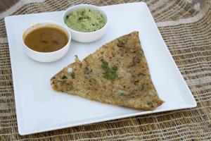 a white plate with a piece of food and a dipping sauce at OYO Way Inn in Kondapur