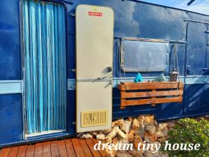 an open door of a blue train with a window at Dream Tiny House or Luxus Tent with pool in Chania