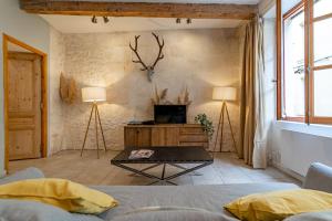 un salon avec un canapé et une télévision dans l'établissement L'élégance de la pierre au pied de la Maison Carrée - Une Nuit à Nîmes, à Nîmes