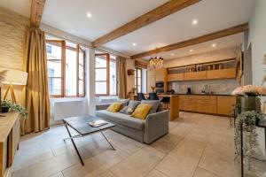 un salon avec un canapé et une cuisine dans l'établissement L'élégance de la pierre au pied de la Maison Carrée - Une Nuit à Nîmes, à Nîmes