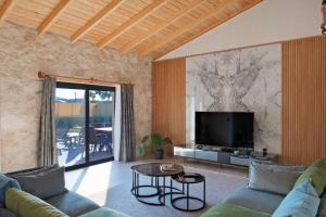 a living room with a couch and a tv at Ader Villa 1 in Fethiye