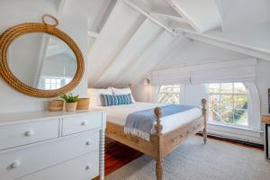 a bedroom with a bed with a mirror and a dresser at Nantucket Periwinkle in Nantucket
