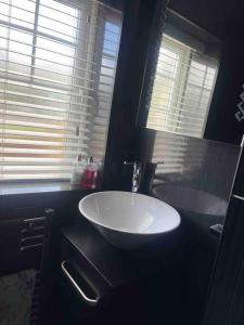 a bathroom with a white sink and two windows at Hidden beauty in peaceful place in Peterlee