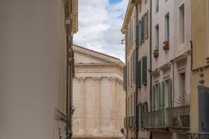 un grand bâtiment au milieu d'une rue dans l'établissement L'élégance de la pierre au pied de la Maison Carrée - Une Nuit à Nîmes, à Nîmes
