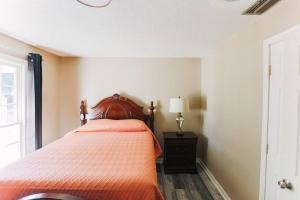1 dormitorio con 1 cama con edredón de naranja en Cozy Downtown Gem Fully Equipped Free Parking, en Mobile