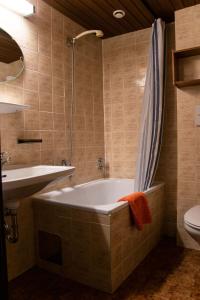 a bathroom with a tub and a sink and a toilet at Hotel Marko in Oetz