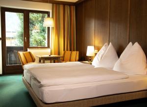 a hotel room with a large bed and a window at Hotel Marko in Oetz