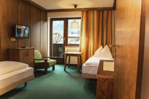a hotel room with two beds and a window at Hotel Marko in Oetz