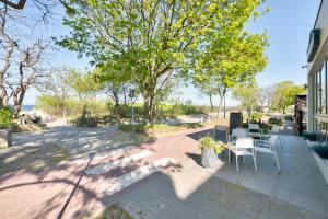 a patio with a table and chairs and a tree at Dom & House - Apartamenty Nautilus Jelitkowo 50 metrów od plaży in Gdańsk