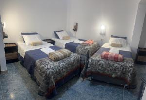 a room with three beds and a chair at Marluc Casa de Descanso in Machu Picchu