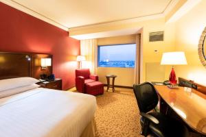 a hotel room with a bed and a desk and a window at Aguascalientes Marriott Hotel in Aguascalientes