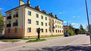 un gran edificio amarillo en el lateral de una calle en Apartament Między Jeziorami, en Augustów