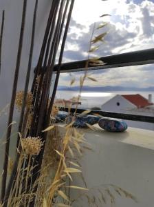 une fenêtre avec vue sur l'océan et une maison dans l'établissement Sunset, à Megalochori