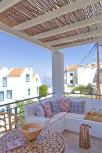 d'une terrasse avec un canapé et une table sur un balcon. dans l'établissement Sunset, à Megalochori