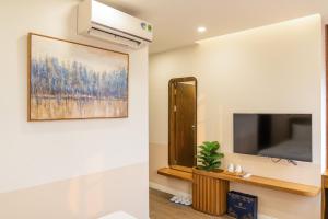 een woonkamer met een tv en een spiegel bij Palo Santo Hotel Phu Quoc in Phu Quoc