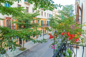 eine leere Straße mit blühenden Bäumen und Gebäuden in der Unterkunft Palo Santo Hotel Phu Quoc in Phu Quoc