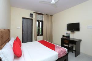 a bedroom with a bed and a desk and a television at OYO Hotel Awesome Villa Near Appu Ghar in Gurgaon
