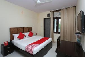 a bedroom with a bed and a flat screen tv at OYO Hotel Awesome Villa Near Appu Ghar in Gurgaon