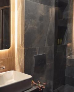 y baño con lavabo y espejo. en Aqua Mare Hotel en Nea Kalikratia