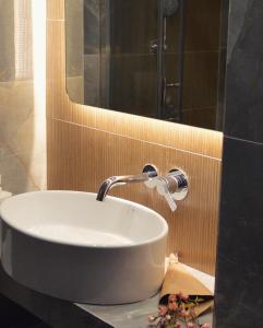 a white sink in a bathroom with a mirror at Aqua Mare Hotel in Nea Kallikrateia