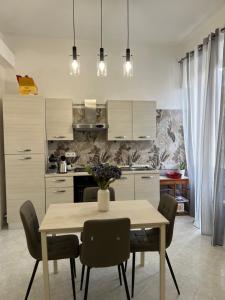 uma cozinha com mesa e cadeiras e uma cozinha com armários brancos em Port House em Civitavecchia