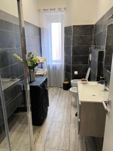 La salle de bains est pourvue d'un lavabo, de toilettes et d'une douche. dans l'établissement Port House, à Civitavecchia