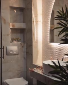 ネア・カリクラティアにあるAqua Mare Hotelのバスルーム(洗面台、トイレ、鏡付)