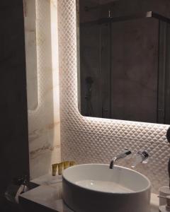 a bathroom with a sink and a mirror at Aqua Mare Hotel in Nea Kalikratia