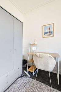 Habitación blanca con escritorio y espejo. en Tiny home at Dundee, en Dundee