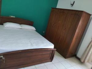 a bedroom with a wooden bed and a wooden dresser at Rudra Residence Apartment in Colombo