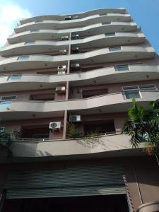 a tall apartment building with palm trees in front of it at Rudra Residence Apartment in Colombo