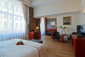 une chambre d'hôtel avec un lit et un salon dans l'établissement Belvedere, à Prague