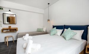 a bedroom with a large white bed with blue pillows at Linden Apartments in Potos