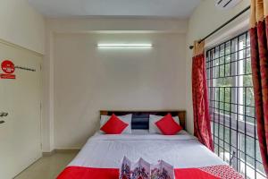 um quarto com uma cama com almofadas vermelhas e azuis em OYO Flagship 15148 Sky Pix Near Kasi Talkies em Chennai