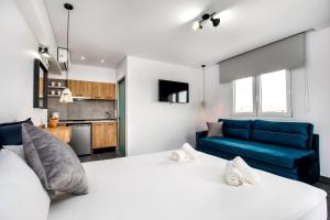 a bedroom with a large bed and a blue couch at Linden Apartments in Potos