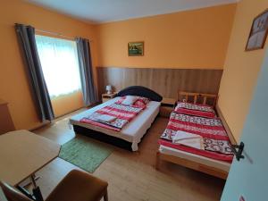 1 dormitorio con 2 camas y ventana en Hotel Béke Sziget Komló, en Komló