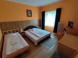 a small room with two beds and a window at Hotel Béke Sziget Komló in Komló
