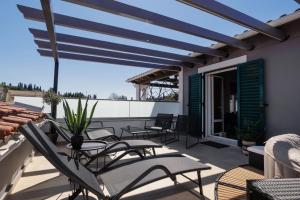 a patio with chairs and tables on a roof at MM luxury studios&villas in Kompítsion
