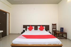 a bedroom with a large bed with red pillows at OYO 16646 Hotel Jyoti in Bikaner