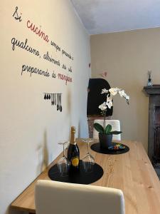 a dining room table with a bottle of wine on the wall at La Casetta in Montefegatesi +21 photos