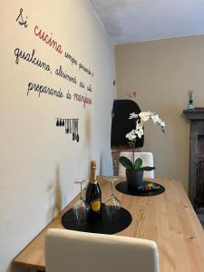 - une table à manger avec une bouteille de vin sur le mur dans l'établissement La Casetta, à Montefegatesi