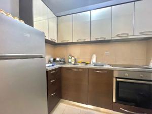 a kitchen with white cabinets and a stainless steel refrigerator at Family One bedroom apartment with Garden view in Budva