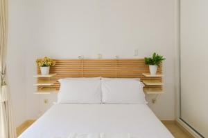 1 dormitorio con 1 cama blanca y 2 almohadas en Espectacular apartamento. en Benalmádena