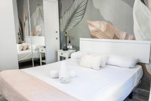 - une chambre avec un lit blanc et un miroir dans l'établissement Apartamento Lineros, à Cordoue