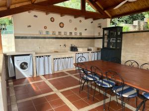 Villa Aileen في ماكاري: مطبخ مع طاولة وكراسي وغسالة ملابس