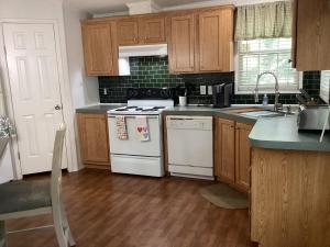 a kitchen with wooden cabinets and a white stove top oven at Hidden Gem on the Tracks in Montgomery
