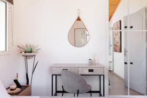 a bedroom with a desk with a chair and a mirror at MM luxury studios&villas in Kompítsion